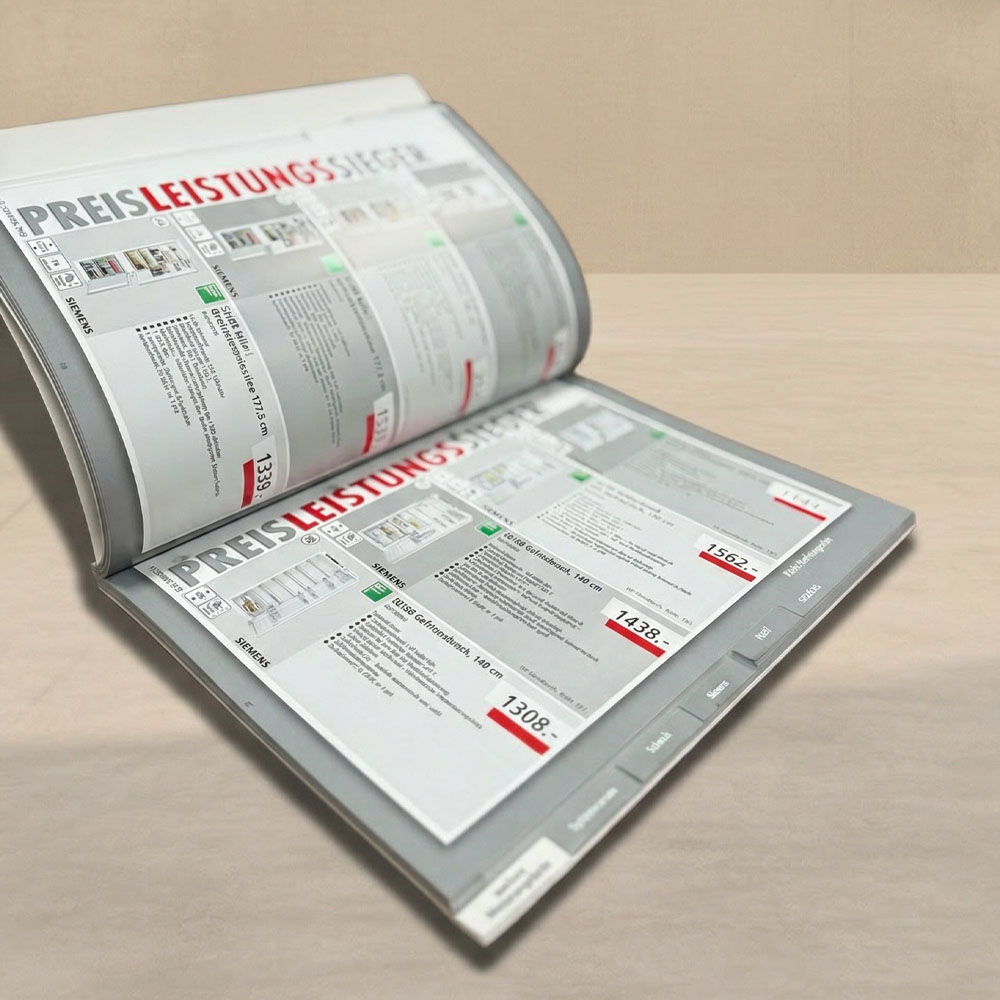 Ein offener Produktkatalog in Grau mit grau-weiß-roten Textelementen, inkl. Registerstanzung